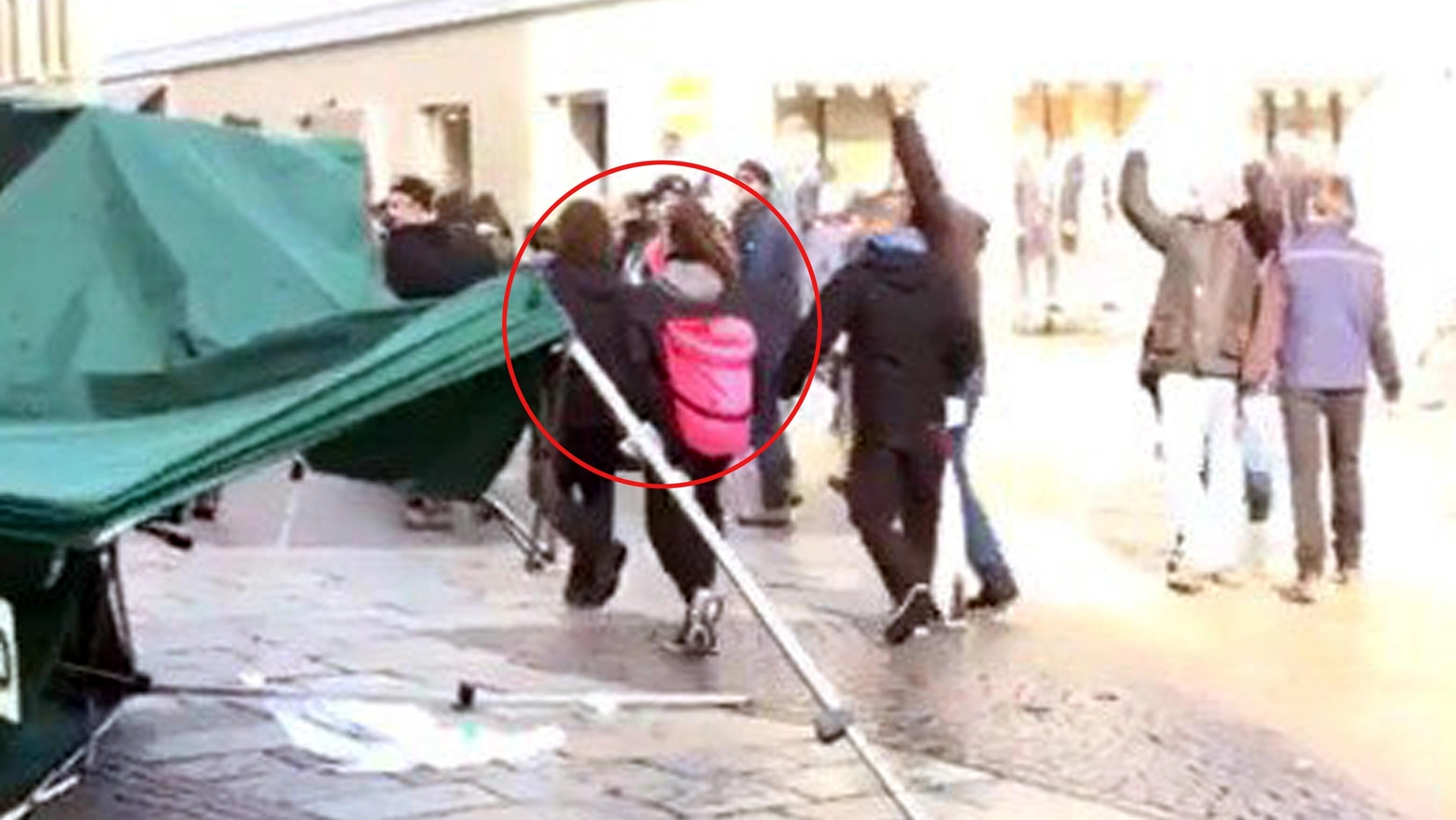 Un fotogramma del video dell'aggressione al gazebo leghista di via Italia a Monza. Cerchiata in rosso Ilaria Salis mentre allontana uno dei manifestanti
