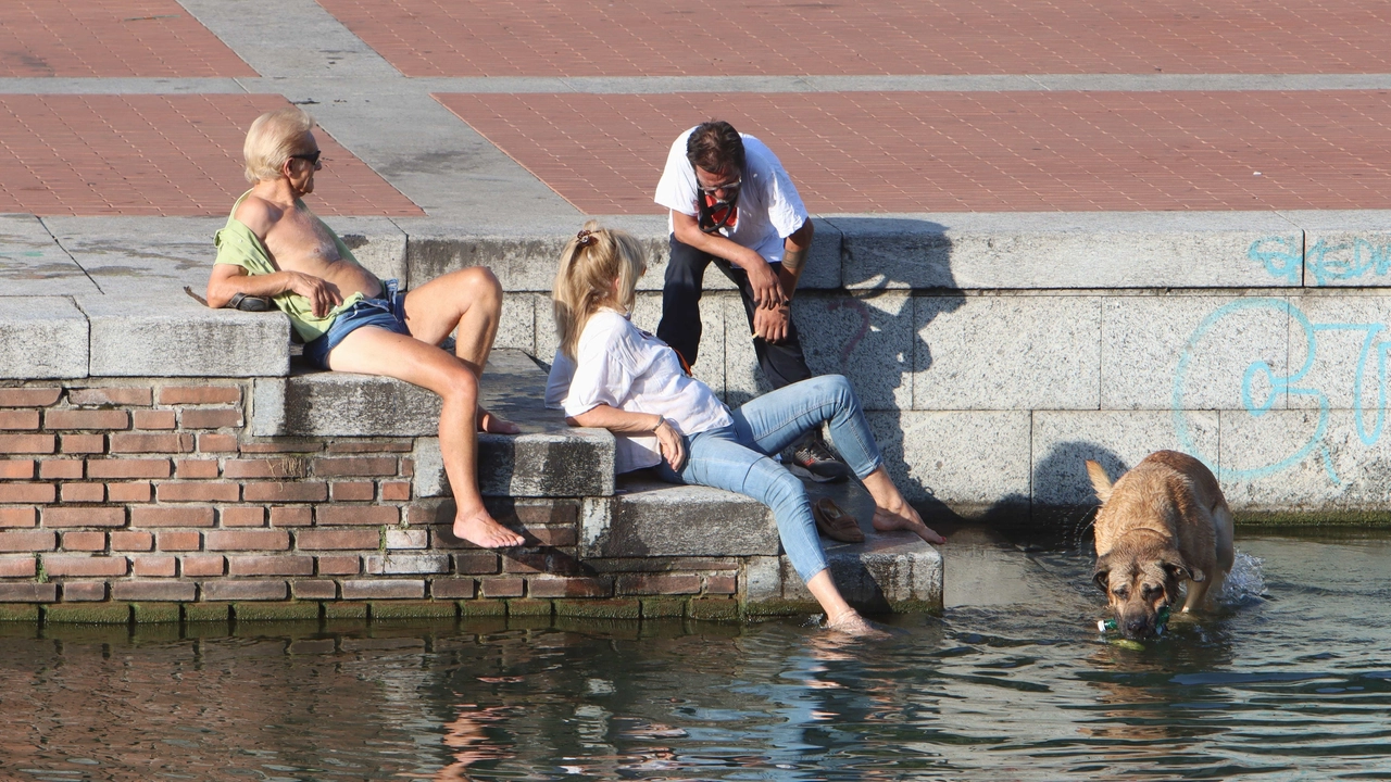 Milanesi cercano ristoro dal caldo nel Naviglio (Ansa/Paolo Salmoirago)