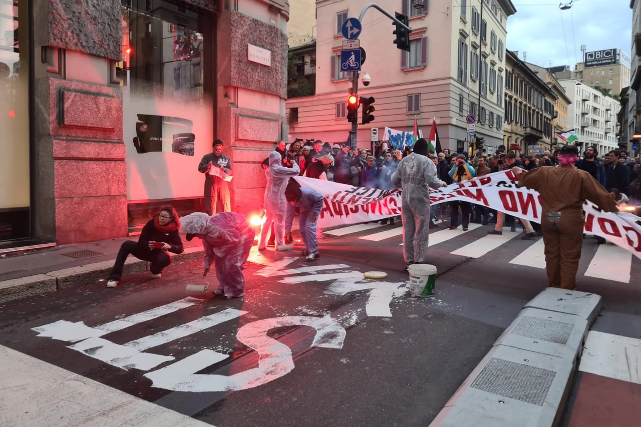 Alcuni manifestanti tracciano la scritta "No War" sull'asfalto davanti alla Prefettura (Foto Fasani)