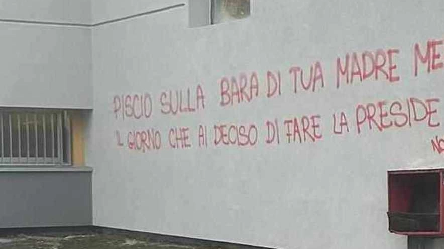 La scritta di minacce contro la preside apparsa sul muro dell'Istituto Curie-Sraffa di via Fratelli Zoia