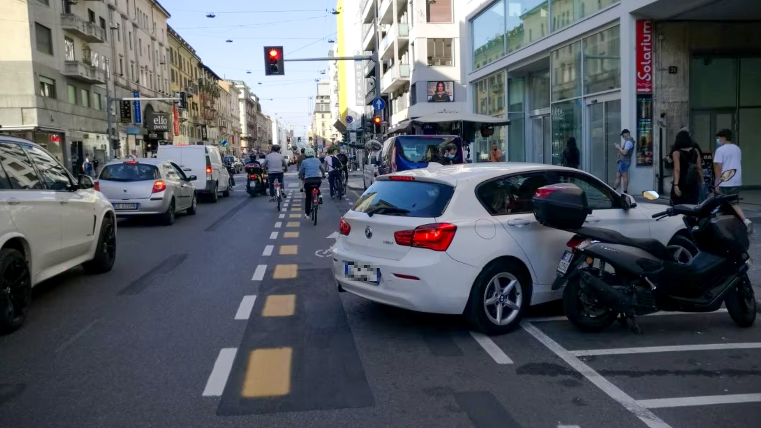 Un'auto parcheggiata in una sosta per motoveicoli invade la pista ciclabile in corso Buenos Aires