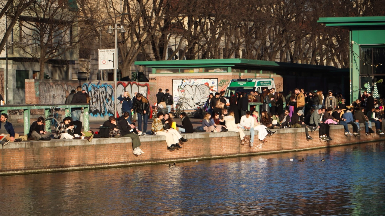 Gruppi di milanesi si godono il sole sulle sponde nei Naviglio, 3 febbraio 2024 (Ansa/Paolo Salmoirago)