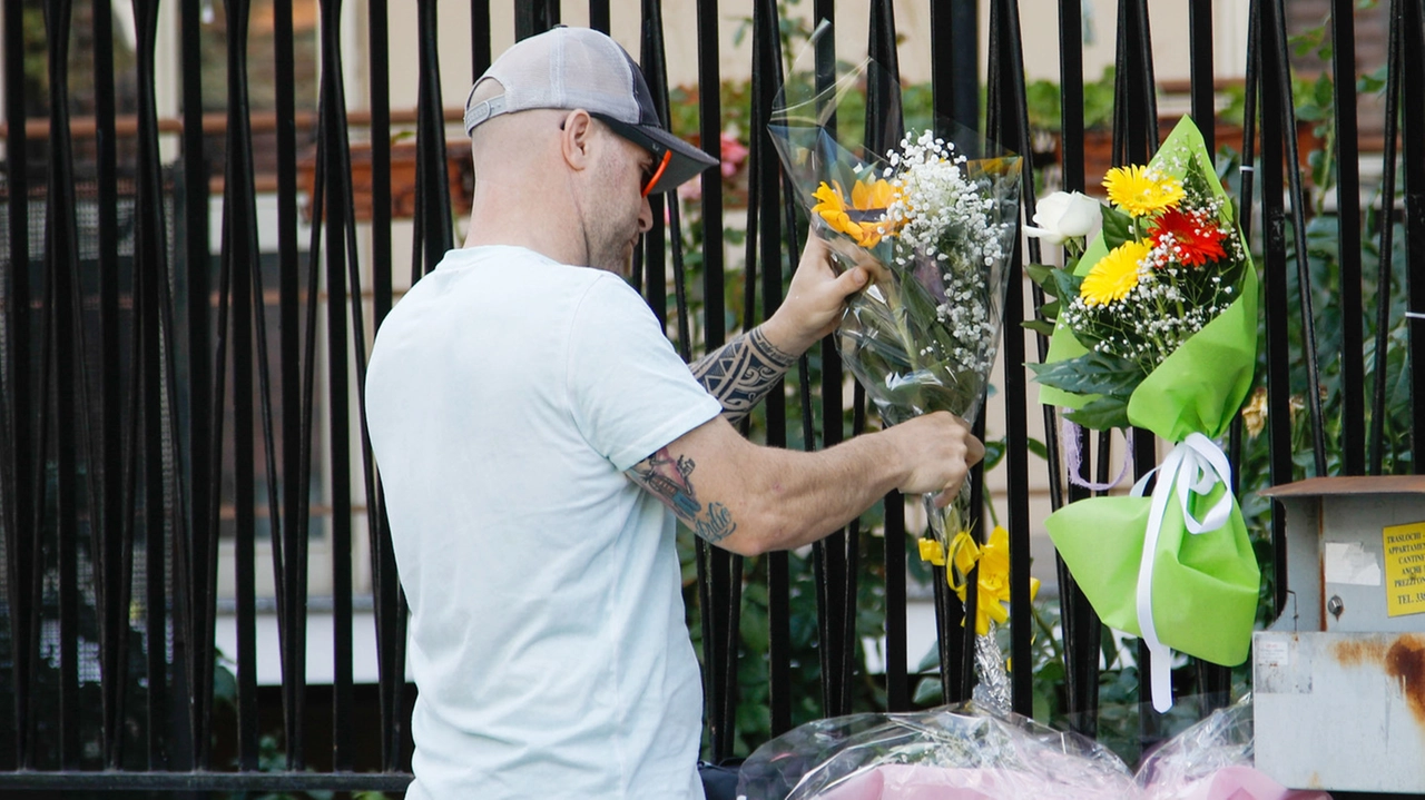 Un uomo attacca un mazzo di fiori al cancello del condominio di corso Roma 100, dove Sofia è stata uccisa all’alba di sabato