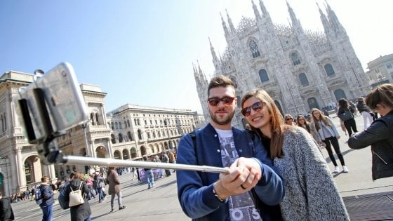 Una coppia di giovani si fa un “selfie“ in Piazza Duomo con vista sulla Cattedrale: l’afflusso di turisti in città resta alto