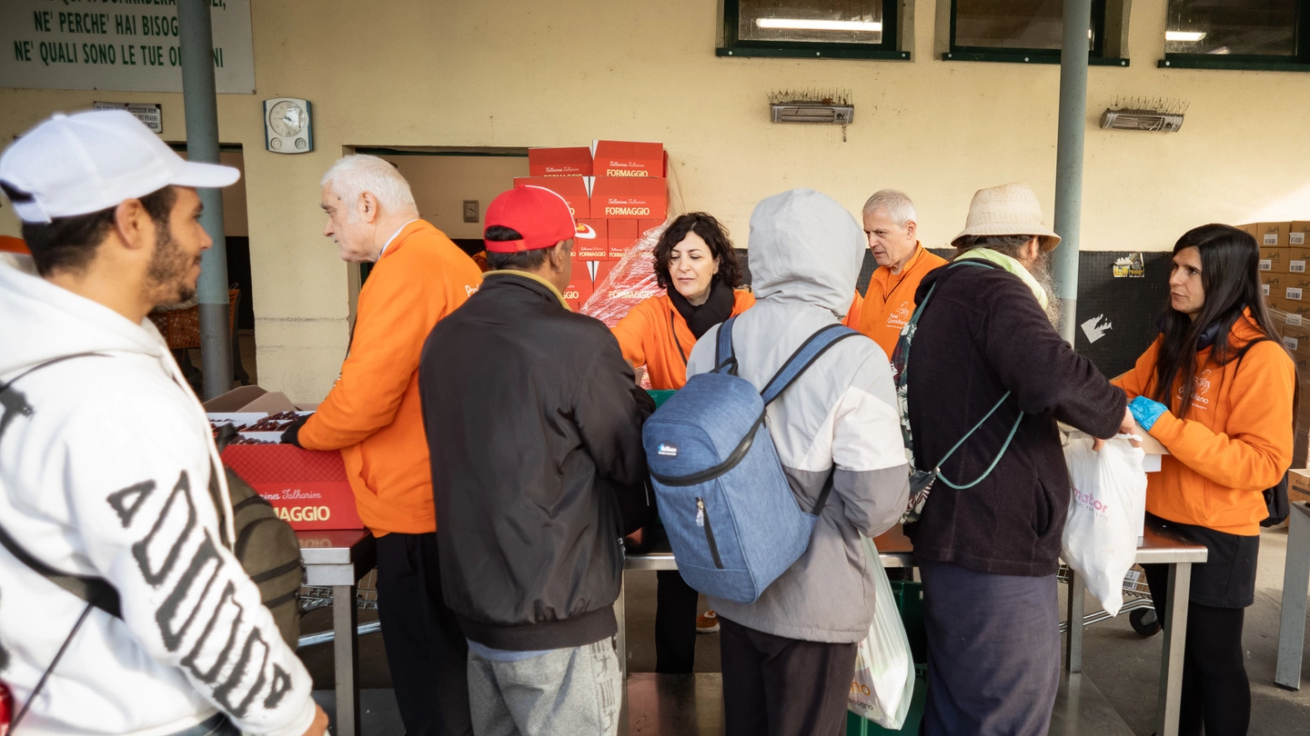 Code al Pane Quotidiano per i pacchi alimentari gratuiti, segno della povertà a Milano