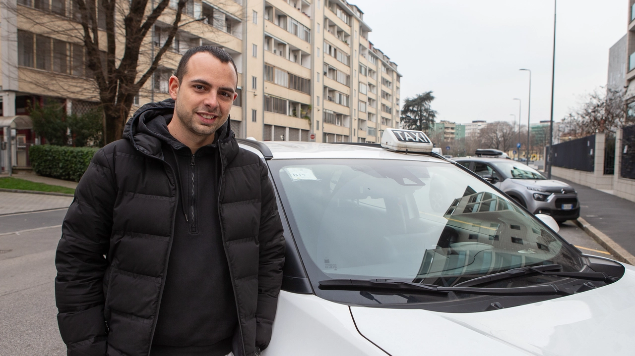 Il tassista Marco Maffei a fianco della sua auto bianca, una Toyota RAV4