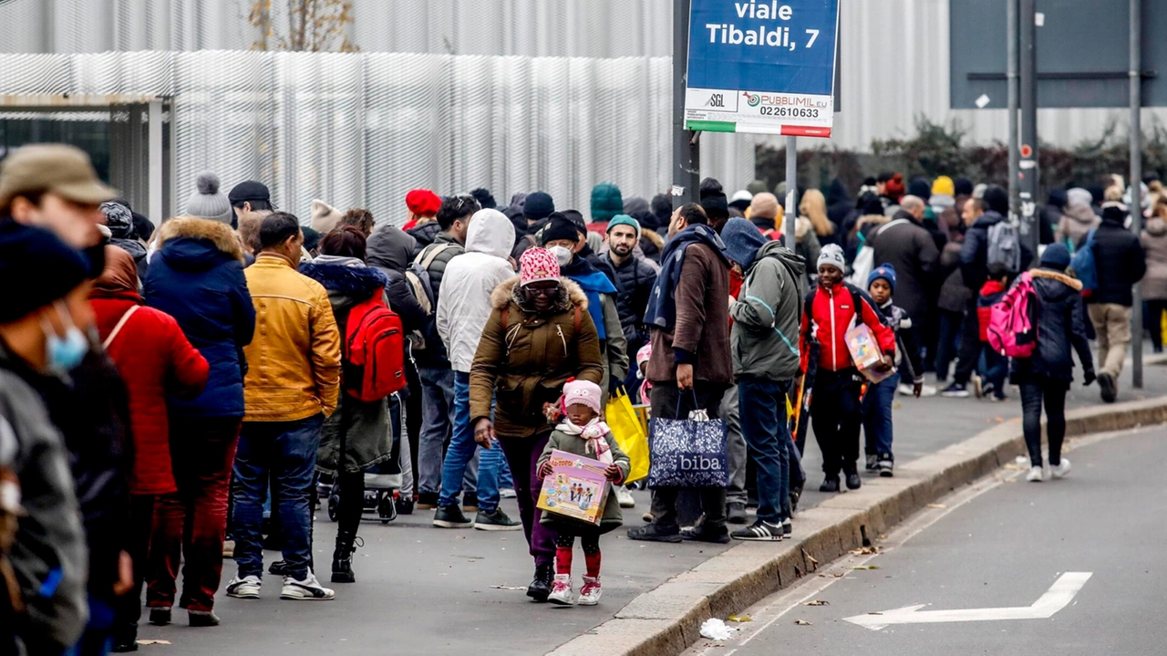 Lunga fila di persone bisognose per la distribuzione di alimenti al Pane Quotidiano di viale Toscana a Milano