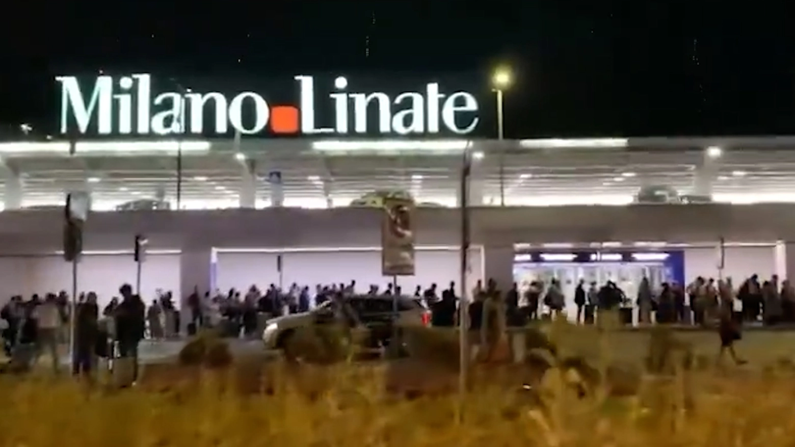 La coda di diverse centinaia di metri formata da persone in attesa di un taxi davanti all'aeroporto di Milano Linate