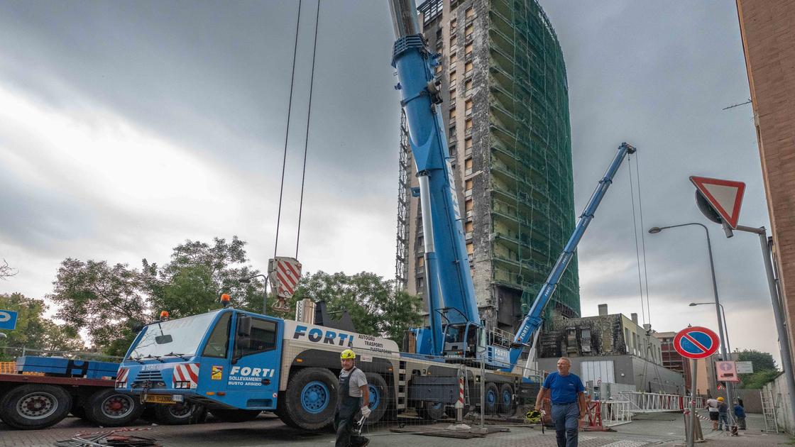 Torre dei Moro, spunta una gru sul grattacielo divorato dall’incendio: “Ora comincia la nostra rinascita”