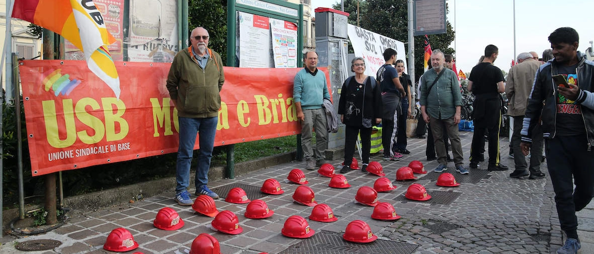 Un presidio organizzato in largo Mazzini, per terra una trentina di caschetti rossi sotto lo striscione rosso della Usb