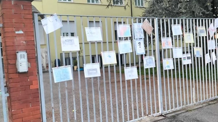 All’entrata della scuola è comparsa la singolare protesta con i bimbi che hanno colorato la cancellata della scuola con disegni e slogan