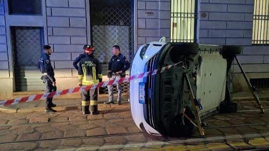 Si stacca un massello. Taxi ribaltato in centro