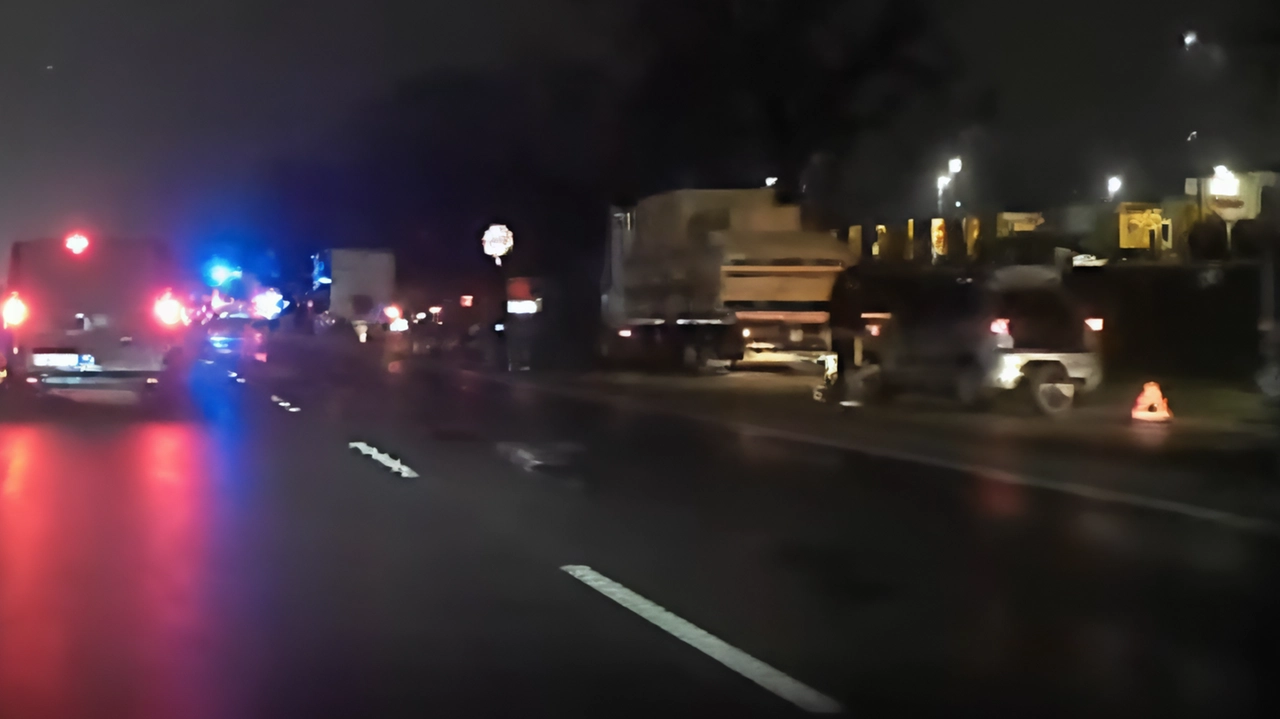 Auto a bordo strada con le quattro frecce accese, il conducente guarda sconsolato la ruota che si è afflosciata....