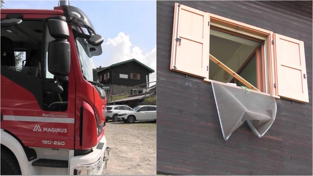 A sinistra un camion dei pompieri, a destra una finestra spalancata dopo l'esplosione nel rifugio in Valtellina