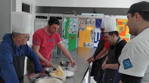 I ragazzi della cooperativa mentre preparano il dolce dell’inclusione