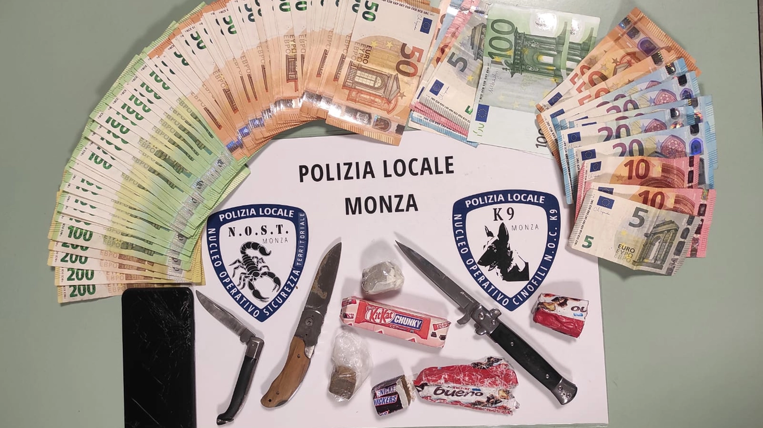 I contanti, le confezioni di droga e i coltelli rinvenuti dalla polizia locale di Monza