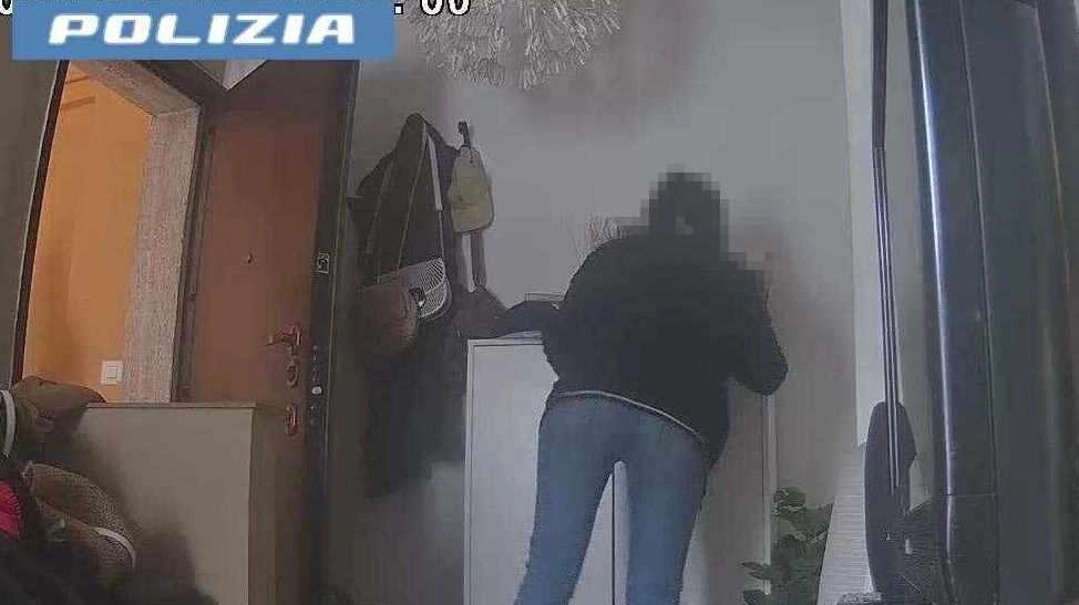 Una delle due donne intenta a rovistare dentro un mobile all’ingresso di casa