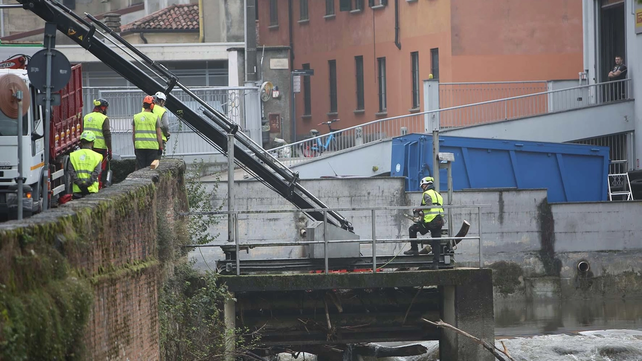 Gli operai al lavoro per la rimozione dei detriti che erano andati a intasare il Lambro rischiando di favorire le esondazioni