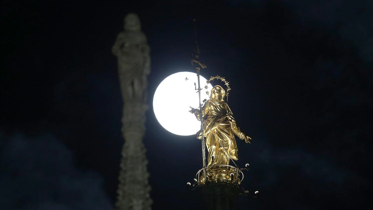 Una luna al perigeo dietro la Madonnina del Duomo di Milano