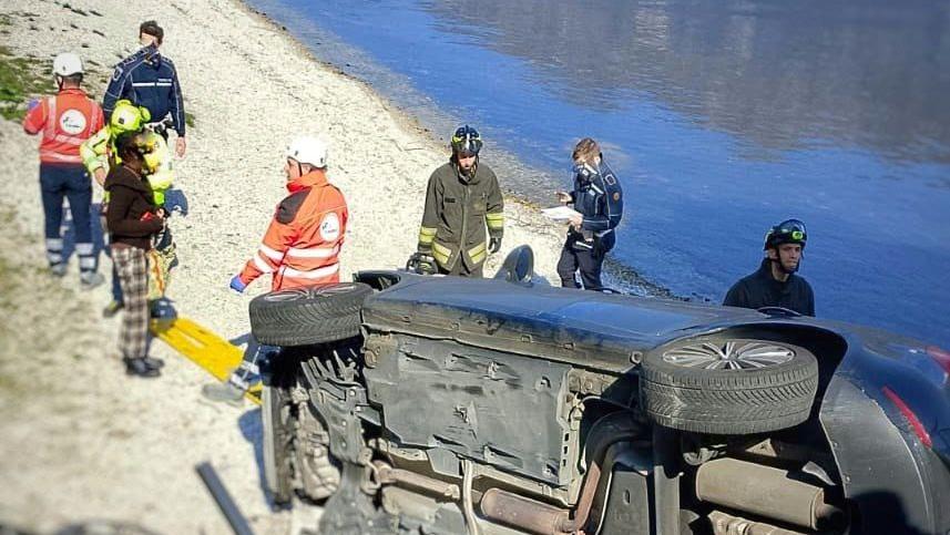 Incidente a Oliveto Lario, auto finisce fuori strada e si ribalta sulla riva del lago: due feriti incastrati nell’abitacolo